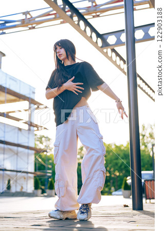 Young dancer showcases contemporary style in urban outdoor setting during golden hour Young dancer showcases contemporary style in urban outdoor setting during golden hour 122903188