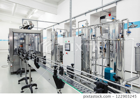 Modern processing line featuring stainless steel machinery in a clean factory environment 122903245