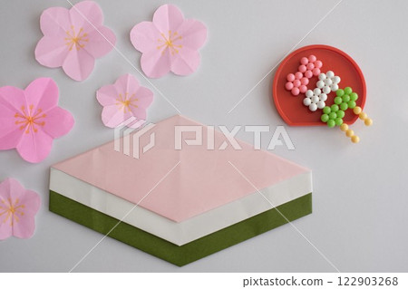 Diamond-shaped rice cakes made with origami paper and three-colored rice dumplings made with Aquabeads 122903268