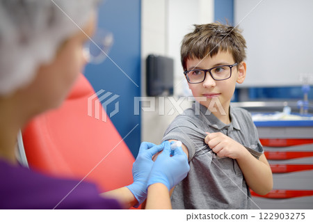 A boy is being vaccinated. A child is given a vaccine during an epidemic or outbreak of a disease. A boy is being vaccinated. A child is given a vaccine during an epidemic or outbreak of a disease. 122903275