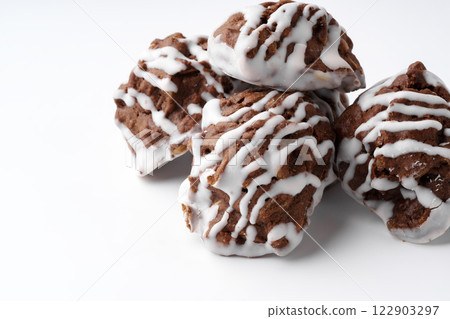 Delicious chocolate cookies drizzled with white icing on a white background 122903297