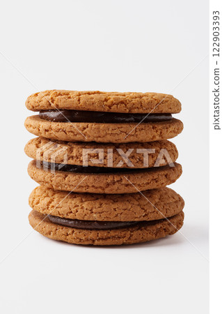 Stack of freshly baked cookies with chocolate filling on a plain background 122903393