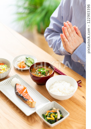 Hands of a middle-aged woman eating a Japanese breakfast 122903396