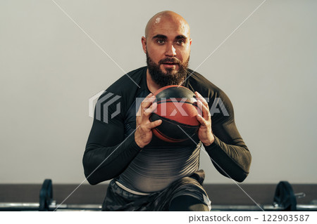 Fitness enthusiast engages in strength training with medicine ball in a gym setting 122903587