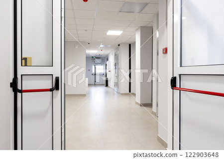 Modern hospital corridor showcasing clean lines and bright lighting in a well-maintained healthcare facility 122903648
