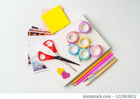 Crafting supplies arranged on a white table with scissors, washi tape, and colored pencils for creative projects Crafting supplies arranged on a white table with scissors, washi tape, and colored pencils for creative projects 122903652