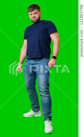 Man expressing confusion with crossed arms in front of a bright green background Man expressing confusion with crossed arms in front of a bright green background 122903706