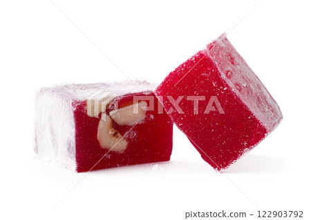 Ruby red jelly cubes with nuts on a white background showcasing a colorful dessert treat 122903792