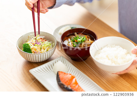 Hands of a middle-aged woman eating a Japanese breakfast 122903936
