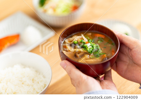 Hands of a middle-aged woman eating a Japanese breakfast 122904009