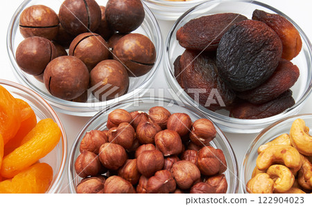Set of nuts and dried apricots in a bowls Set of nuts and dried apricots in a bowls 122904023