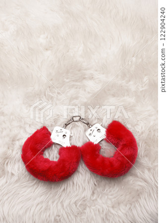 Red sexy fluffy handcuffs on a fur 122904240