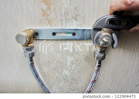 An adjustable pliers wrench is used to fasten pipe plugs, securing them tightly to plumbing mount. An adjustable pliers wrench is used to fasten pipe plugs, securing them tightly to plumbing mount. 122904473