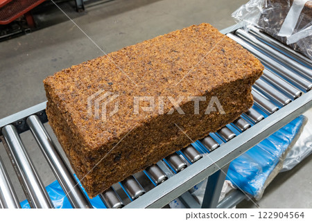 The close up image of the jagged brown natural raw rubber bales surface, lumpy solid block standard Thai rubber, in a factory. 122904564