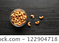 Cashew nuts in bowl on a wood 122904718