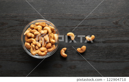 Cashew nuts in bowl on a wood 122904718