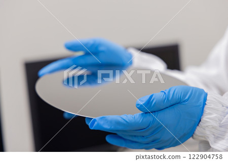Engineer inspecting a silicon wafer Engineer inspecting a silicon wafer 122904758