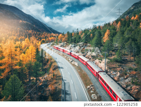 Aerial view of red train, river in mountains, road, orange forest Aerial view of red train, river in mountains, road, orange forest 122905258