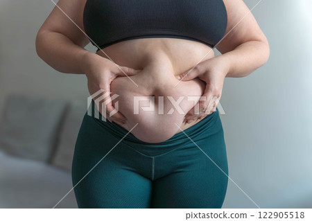 Close up tummy of a woman with fat belly 122905518