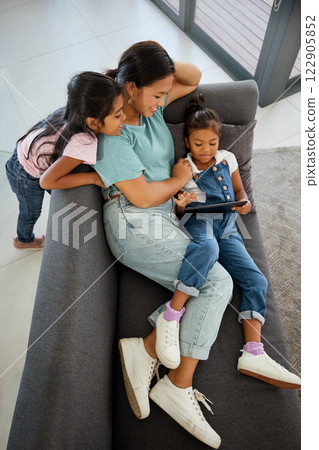 Family tablet, sofa relax and mother on the internet with children, happy with subscription service show on tech and happy with games on web in house. Sisters watching video on technology with mom 122905852