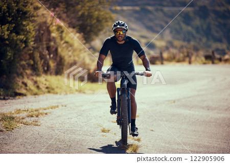 Fitness, mountain and man cycling on a bicycle in summer for exercise, training and cardio workout on the road. Lifestyle, wellness and strong cyclist enjoys riding his mountain bike alone outdoors 122905906