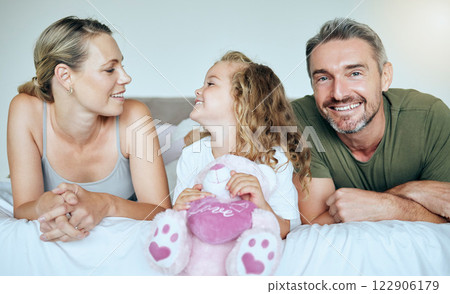 Happy, smile and family relaxing on a bed while bonding in their calm and comfortable bedroom. Happiness, love and care between parents and a girl child holding a teddy while resting in a modern home Happy, smile and family relaxing on a bed while bonding in their calm and comfortable bedroom. Happiness, love and care between parents and a girl child holding a teddy while resting in a modern home 122906179