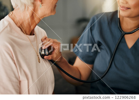 Cardiology consultation, doctor and senior woman consulting about healthcare on living room sofa in retirement home. Hand of nurse with stethoscope while helping elderly patient with medical service 122906268