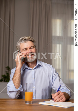 Smiling businessman working at the home office and looking determined 122906303