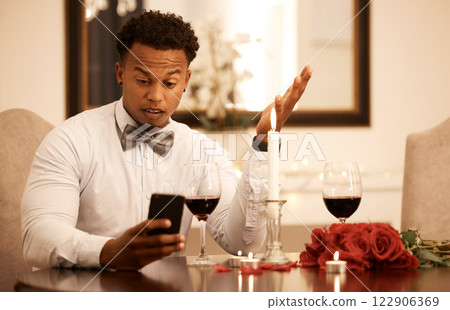 Confused, angry and phone fail of a date of a black man waiting at a restaurant table. Internet 5g video call of a guy using smartphone to ask a why question and check late time on Valentines Day 122906369