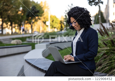Manager sitting in the business area park and working on laptop 122906452