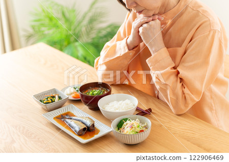 一位中年婦女擔心她的日式早餐 一位中年婦女擔心她的日式早餐 122906469