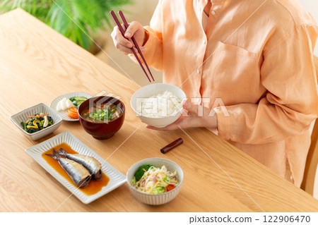 Middle-aged woman eating Japanese breakfast Middle-aged woman eating Japanese breakfast 122906470