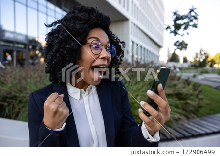 Curly-haired brunette business woman looking excited after having a good news Curly-haired brunette business woman looking excited after having a good news 122906499