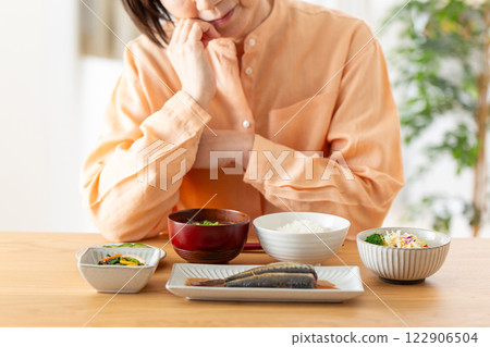 A middle-aged woman worried about her Japanese breakfast 122906504