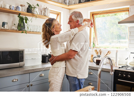 Happy senior couple, love and care embracing relationship bonding together in the kitchen at home. Elderly man and woman hugging, relaxing and enjoying a holiday break of romance in happiness indoors 122906508