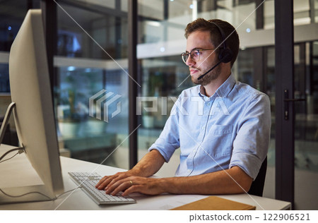 Call center, web communication and businessman working as consultant as telemarketing company in dark office. Customer service worker consulting on internet during night shift and overtime at startup 122906521