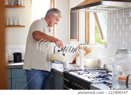 Retirement man and kettle for tea in kitchen preparation for leisure drink in New Zealand home. Senior, healthy and mature guy enjoying pension lifestyle relaxing in house with a cup of coffee 122906547