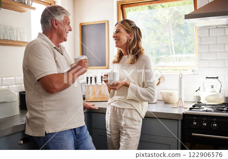 Relax, coffee and elderly couple bonding in a kitchen, talking and laughing in their home together. Love, retirement and mature man and woman enjoy morning conversation, relaxing and drinking coffee 122906576