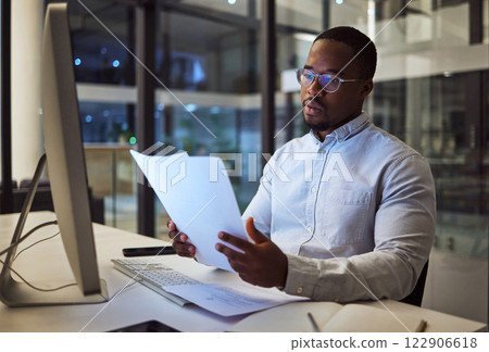 Night worker, black businessman and paperwork planning, reading documents and financial reports at desktop computer in Jamaica. Young focus entrepreneur working expert strategy in dark modern office Night worker, black businessman and paperwork planning, reading documents and financial reports at desktop computer in Jamaica. Young focus entrepreneur working expert strategy in dark modern office 122906618