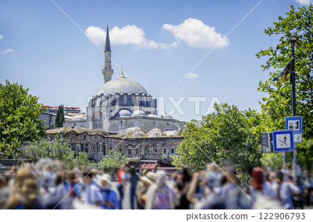 Blurred Crowd of tourists in Istanbul with Ottoman mosque in the background. Bustling city life blending modern tourism with rich cultural heritage. Vibrant urban scene with historic architecture Blurred Crowd of tourists in Istanbul with Ottoman mosque in the background. Bustling city life blending modern tourism with rich cultural heritage. Vibrant urban scene with historic architecture 122906793