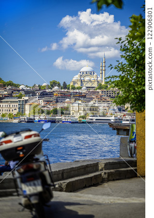 Sulaymaniyah Mosque dominates Istanbul skyline with stunning architecture. Scenic view of the Bosphorus with boats and a parked scooter in the foreground. Travel, cultural heritage concept Sulaymaniyah Mosque dominates Istanbul skyline with stunning architecture. Scenic view of the Bosphorus with boats and a parked scooter in the foreground. Travel, cultural heritage concept 122906801