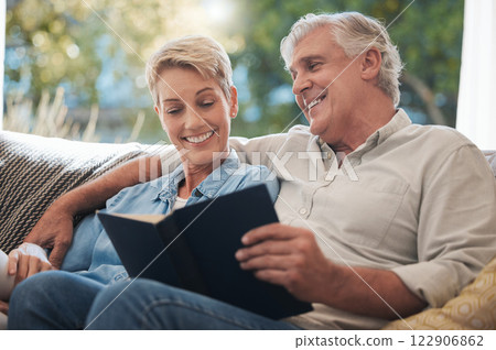 Senior, pension and reading couple with a happy smile at home on a lounge sofa. Love, calm and happiness mindset of a elderly couple with books together looking at pages of a book on a house couch 122906862