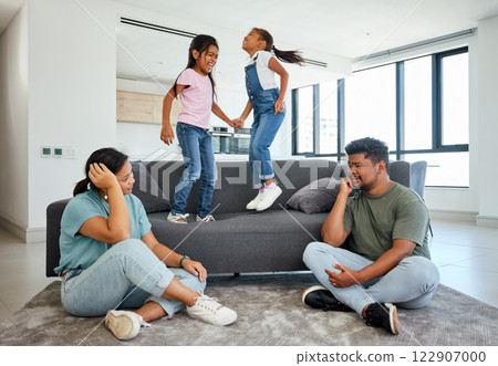 Family, energy and kids jumping on home sofa with tired parents struggling with naughty, hyperactive and playing children. Woman and man with ADHD, noisy and laughing girls, friends or fun twins Family, energy and kids jumping on home sofa with tired parents struggling with naughty, hyperactive and playing children. Woman and man with ADHD, noisy and laughing girls, friends or fun twins 122907000