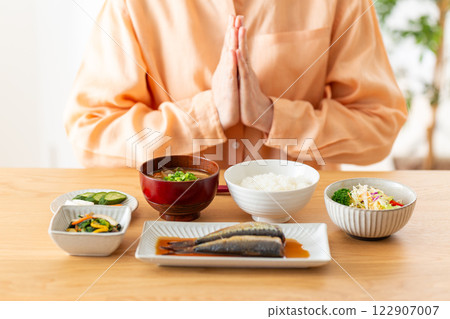 Middle-aged woman eating Japanese breakfast Middle-aged woman eating Japanese breakfast 122907007