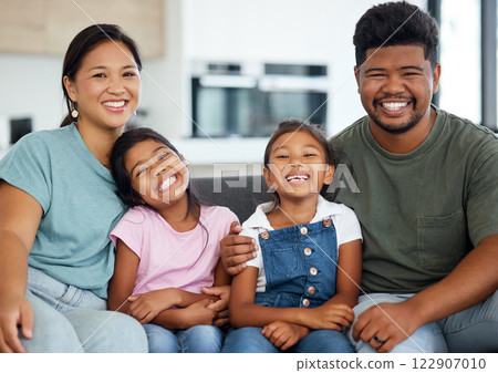 Family, sofa and home smile with happy, kids and parents together, on weekend or holiday. Mom, dad and children in living room, show love and care on vacation or travel in house or hotel in Indonesia 122907010