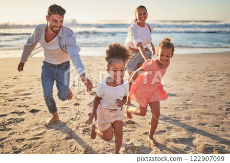 Family, beach and kids with parents running on sand on summer holiday. Mom, dad and children at ocean at sunset in Mexico. Freedom, fun and vacation, happy man and woman playing with girls at the sea 122907099