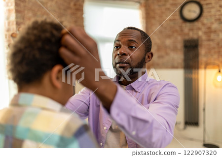 African american bearded man making hair to his son and smiling 122907320