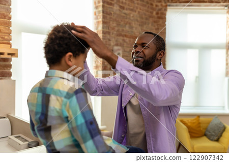 Father and son at home getting dressed in the kitchen and looking enjoyed Father and son at home getting dressed in the kitchen and looking enjoyed 122907342