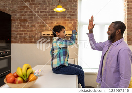 Father and son having good time at home and looking enjoyed 122907346
