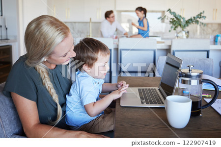 Mother, kid and laptop at table in living room with father and girl in background. Work from home mom on coffee break with son. Child development, family time and relax, a mothers love for children 122907419